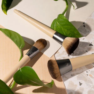 Two skin perfecting makeup brushes shown with bamboo handles and domed bristle heads