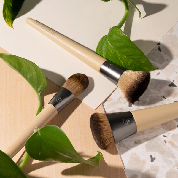 Two skin perfecting makeup brushes shown with bamboo handles and domed bristle heads