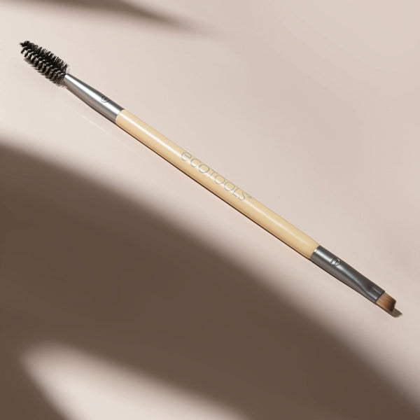 Eyebrow duo brush with beige handle, angled brush tip and black spoolie end