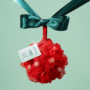 Red mesh lathering pouf with teal satin bow and product tag