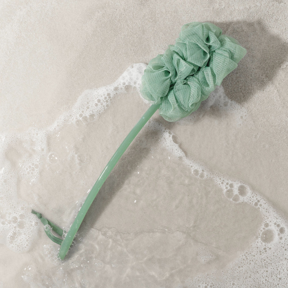 Light green bath pouf brush with ruffled sponge head and handle