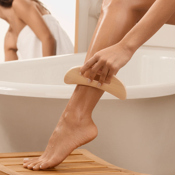 Bamboo body massager used on skin, held by two hands