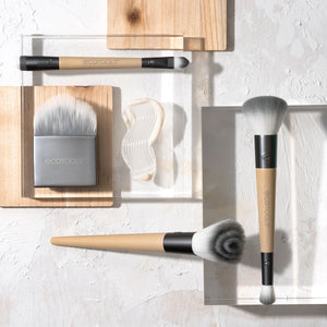 Makeup brush kit with multiple face brushes and ECOTOOLS case on display