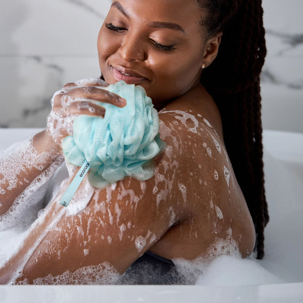 Light blue mesh cleansing pouf used for gentle washing with foam