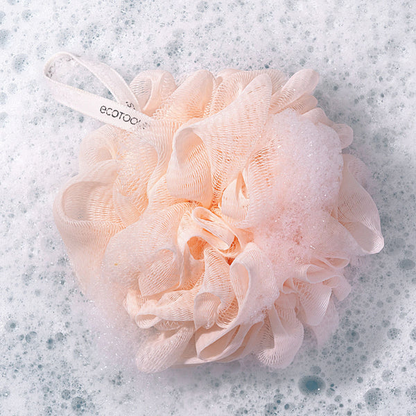 Blush peach loofah sponge with mesh flower texture and white hanging loop