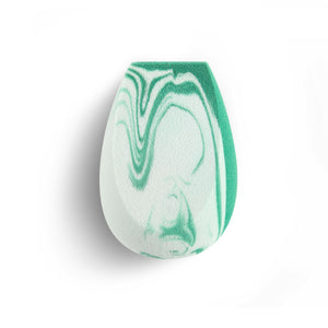 Teardrop blending sponge with white foam and green swirled pattern on surface.