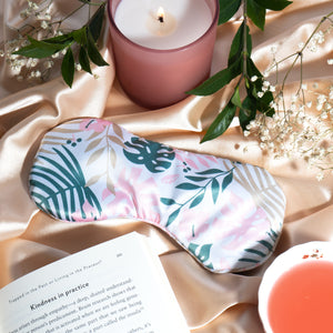 Satin sleep mask with pink, teal, and cream tropical leaf design