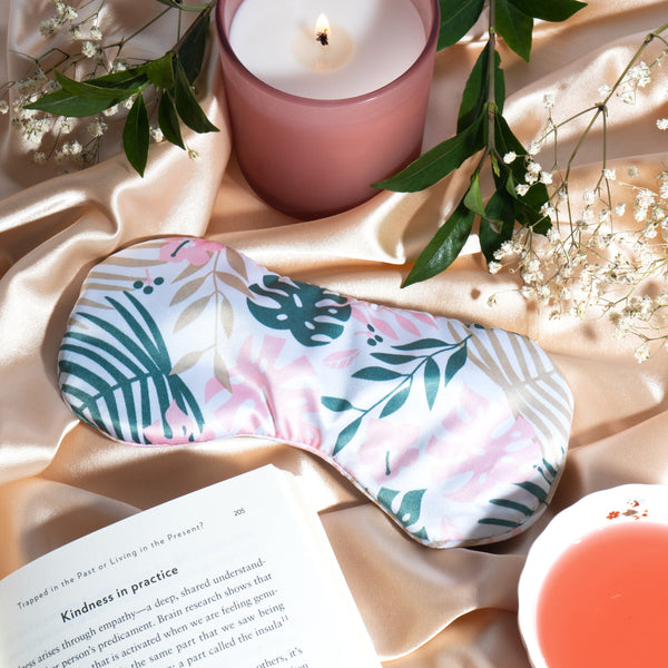 Satin sleep mask with pink, teal, and cream tropical leaf design